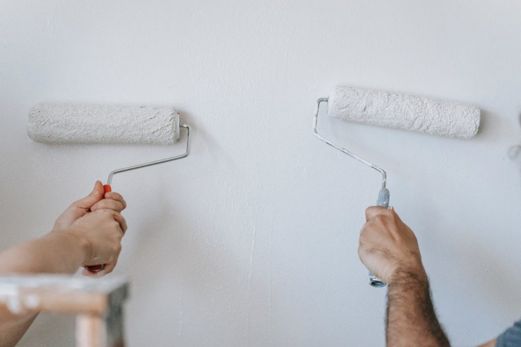 Two people painting a wall