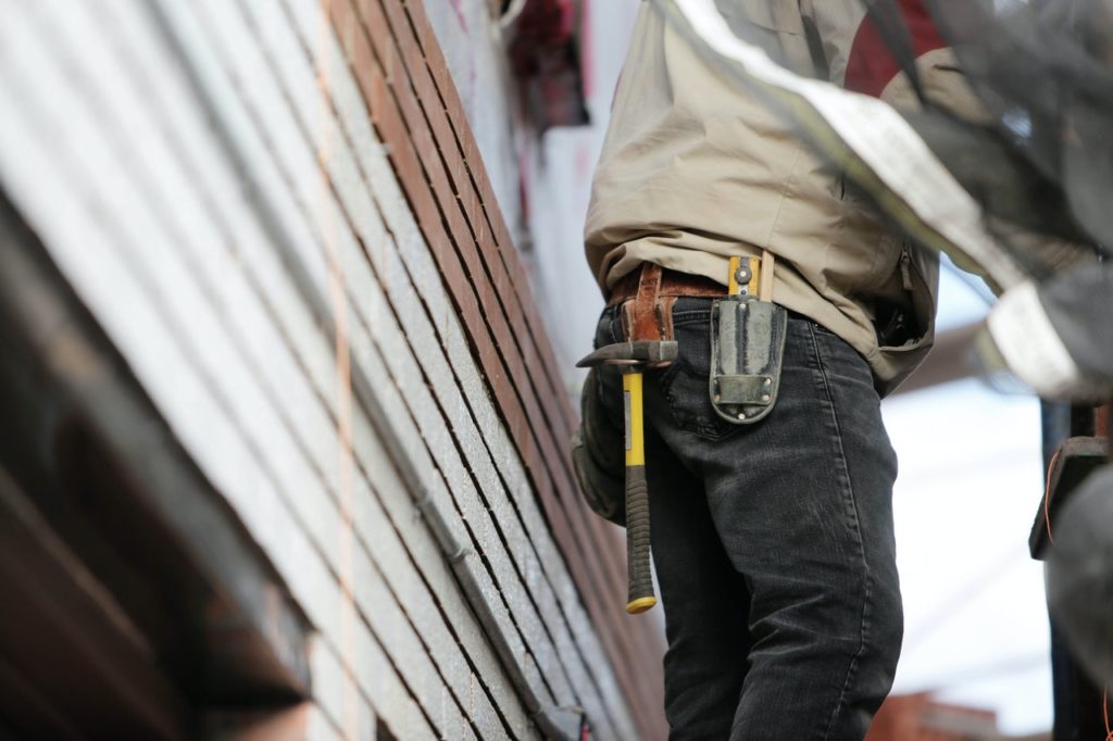 A construction person carrying a hammer