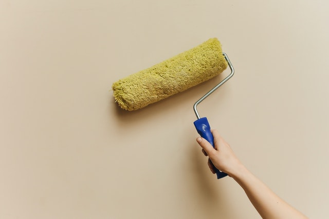  A person holding a paint roller.