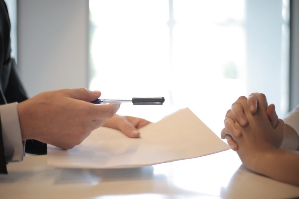 Two people signing a contract which is one of the pieces of advice for avoiding a renovation nightmare.